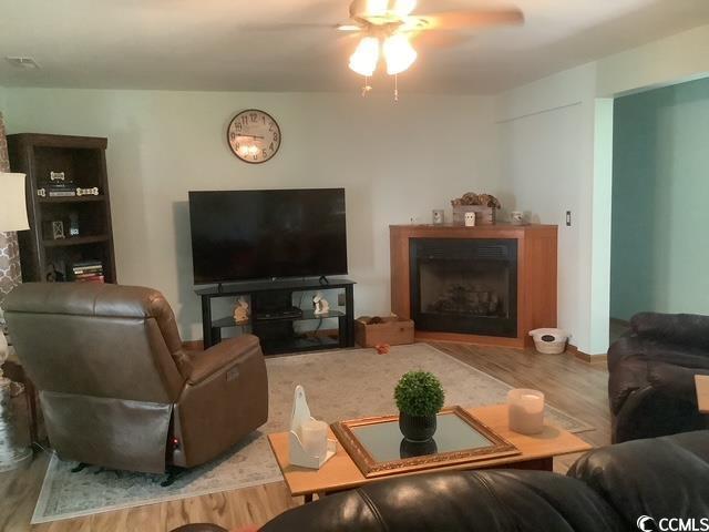 390 Boundary Ave, Murrells Inlet, SC 29576 - living area with a fireplace, wood finished floors, and a ceiling fan