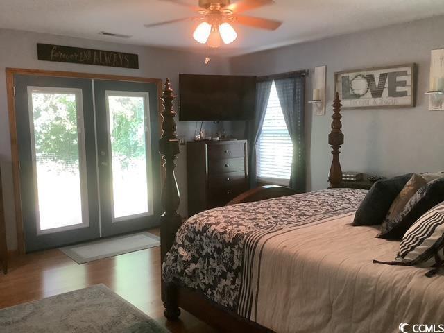 390 Boundary Ave, Murrells Inlet, SC 29576 - bedroom featuring french doors, multiple windows, access to outside, and wood finished floors