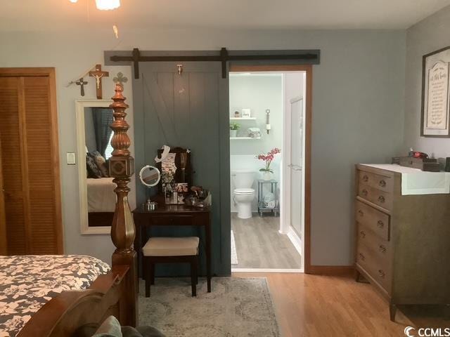 390 Boundary Ave, Murrells Inlet, SC 29576 - bedroom featuring light wood-style flooring, connected bathroom, a barn door, and a closet