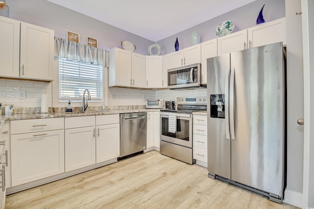 6203 Catalina Dr Unit 935, North Myrtle Beach, SC 29582 - kitchen with appliances with stainless steel finishes, light stone counters, tasteful backsplash, and white cabinets