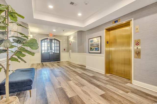 6203 Catalina Dr Unit 935, North Myrtle Beach, SC 29582 - foyer featuring elevator, light wood-type flooring, wallpapered walls, ornamental molding, and a wainscoted wall