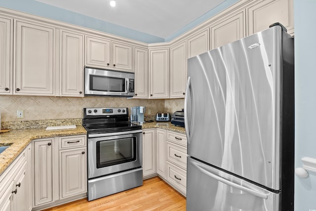 1020 Ocean Blvd S Unit A, Surfside Beach, SC 29575 - kitchen with stainless steel appliances, decorative backsplash, light stone countertops, and light wood finished floors