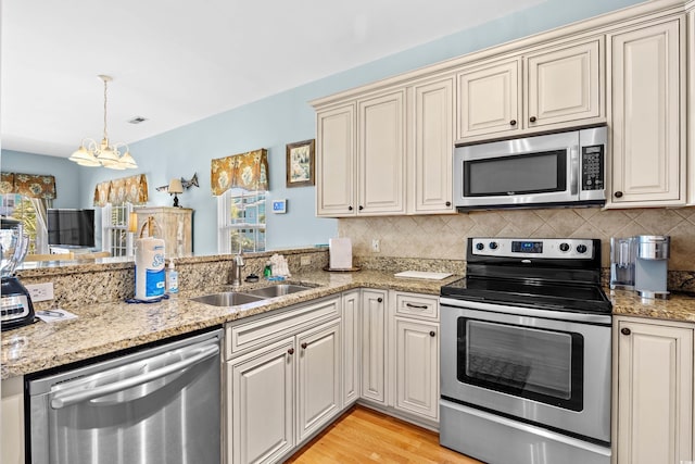 1020 Ocean Blvd S Unit A, Surfside Beach, SC 29575 - kitchen with appliances with stainless steel finishes, a chandelier, cream cabinets, and decorative backsplash