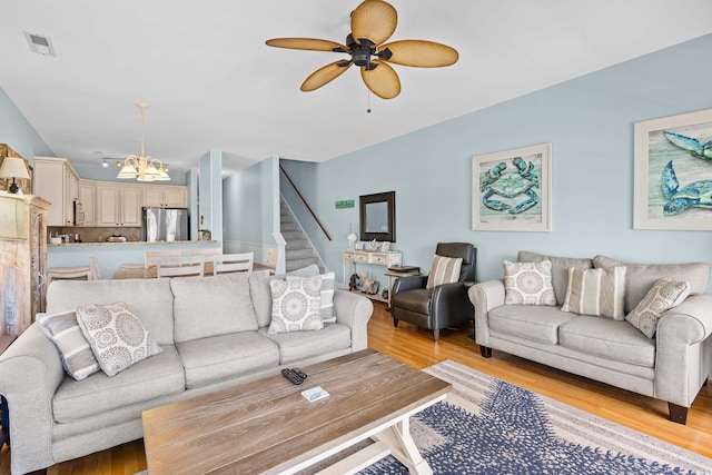 1020 Ocean Blvd S Unit A, Surfside Beach, SC 29575 - living room with light wood finished floors, stairway, a chandelier, and ceiling fan