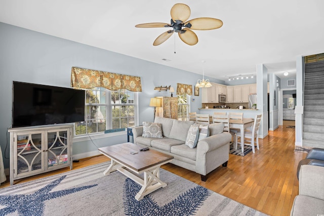 1020 Ocean Blvd S Unit A, Surfside Beach, SC 29575 - living room featuring light wood-style flooring, ceiling fan, stairway, and a chandelier
