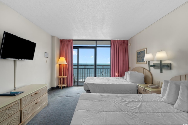 9550 Shore Dr Unit 1537/1538, Myrtle Beach, SC 29572 - carpeted bedroom with floor to ceiling windows, a water view, access to outside, and a textured ceiling