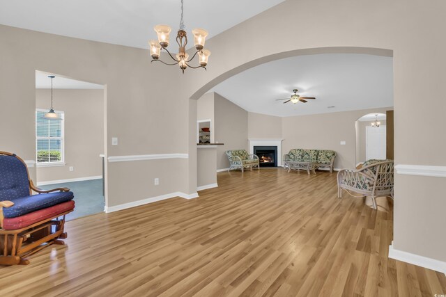 244 Devonbrook Pl, Longs, SC 29568 - living area featuring a ceiling fan, a chandelier, arched walkways, light wood finished floors, and a lit fireplace
