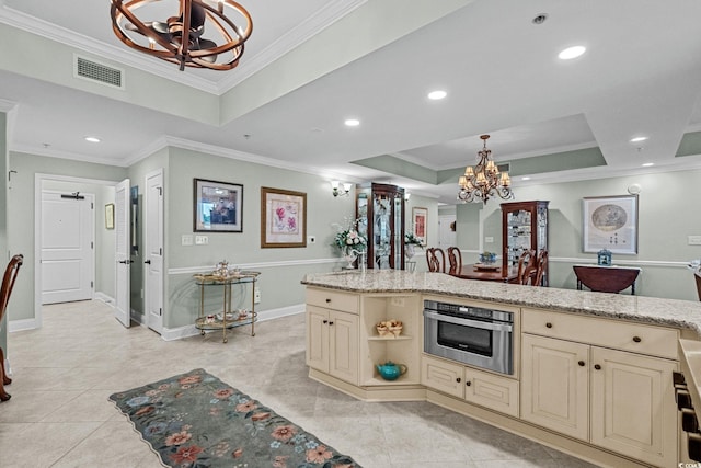 9547 Edgerton Dr Unit 405, Myrtle Beach, SC 29572 - kitchen featuring cream cabinets, a chandelier, a tray ceiling, oven, and ornamental molding