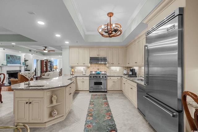 9547 Edgerton Dr Unit 405, Myrtle Beach, SC 29572 - kitchen with high end appliances, cream cabinets, under cabinet range hood, crown molding, and recessed lighting