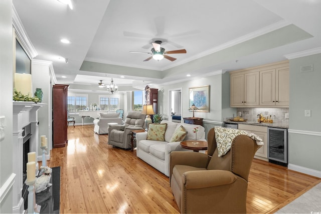 9547 Edgerton Dr Unit 405, Myrtle Beach, SC 29572 - living room with beverage cooler, a tray ceiling, ceiling fan, light wood-style flooring, and crown molding