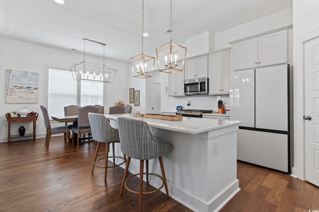 1524 Sayebrook Pkwy, Myrtle Beach, SC 29588 - kitchen with stainless steel microwave, freestanding refrigerator, a chandelier, a breakfast bar, and a kitchen island