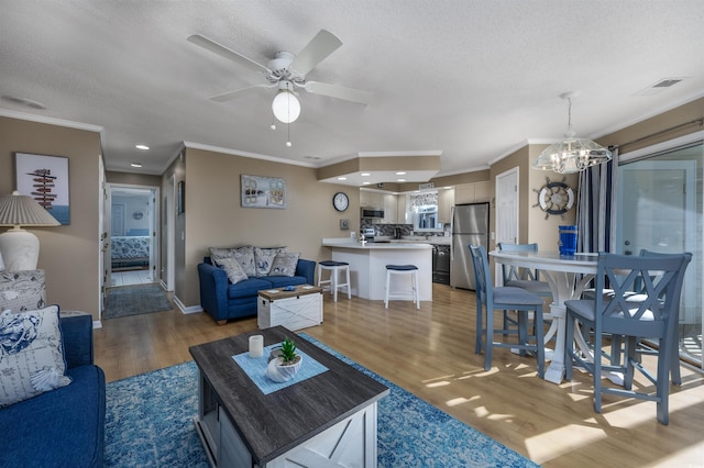 300 Shorehaven Dr Unit I-2, North Myrtle Beach, SC 29582 - living area with crown molding, light wood finished floors, a ceiling fan, a chandelier, and a textured ceiling