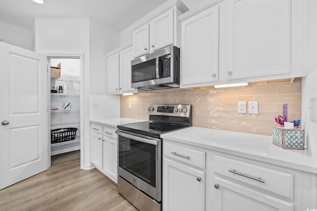 219 Glenmoor Dr, Conway, SC 29526 - kitchen featuring appliances with stainless steel finishes, light countertops, white cabinets, light wood-style floors, and tasteful backsplash