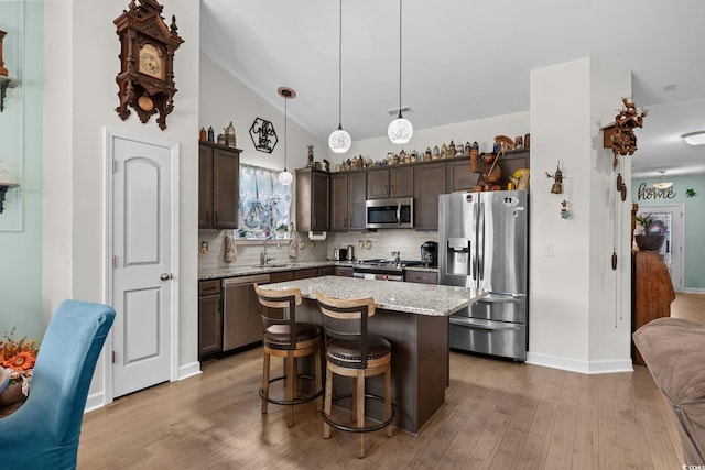 2781 Desert Rose St, Little River, SC 29566 - kitchen featuring stainless steel appliances, dark brown cabinets, light wood-type flooring, tasteful backsplash, and a center island