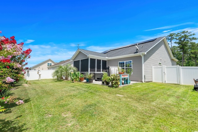 2781 Desert Rose St, Little River, SC 29566 - back of house with a sunroom, roof mounted solar panels, a fenced backyard, and a shingled roof
