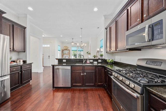1348 Peterson St, Myrtle Beach, SC 29577 - kitchen with stainless steel appliances, dark wood-style flooring, a chandelier, a peninsula, and ornamental molding