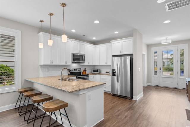 5304 Sea Coral Way N, Myrtle Beach, SC 29582 - kitchen featuring appliances with stainless steel finishes, a peninsula, tasteful backsplash, white cabinets, and dark wood-style flooring