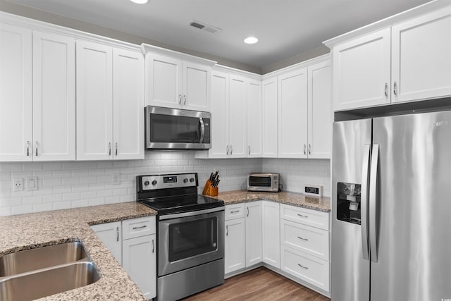 5304 Sea Coral Way N, Myrtle Beach, SC 29582 - kitchen featuring appliances with stainless steel finishes, white cabinets, recessed lighting, and tasteful backsplash