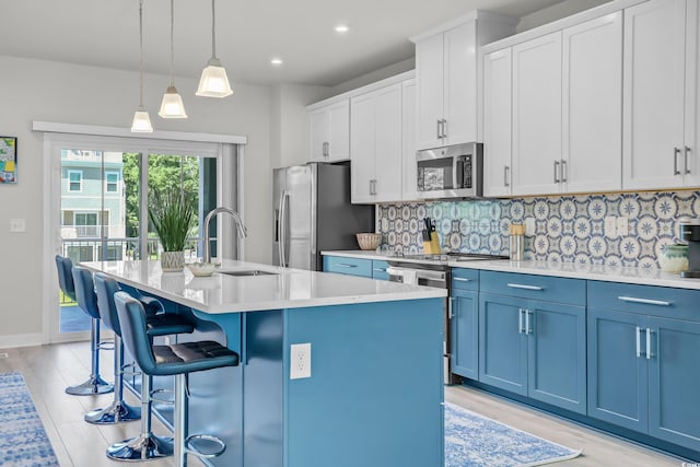 2557 Pete Dye Dr Unit 803, North Myrtle Beach, SC 29582 - kitchen with appliances with stainless steel finishes, blue cabinetry, a kitchen island with sink, tasteful backsplash, and recessed lighting