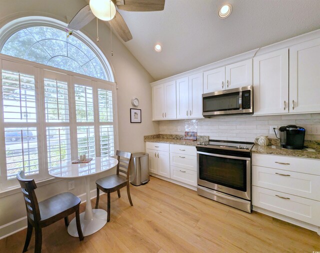 50 Pawleys Place Dr Unit 50, Pawleys Island, SC 29585 - kitchen with appliances with stainless steel finishes, lofted ceiling, backsplash, white cabinets, and recessed lighting