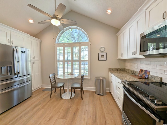 50 Pawleys Place Dr Unit 50, Pawleys Island, SC 29585 - kitchen with stainless steel appliances, vaulted ceiling, white cabinetry, light wood-style flooring, and ceiling fan