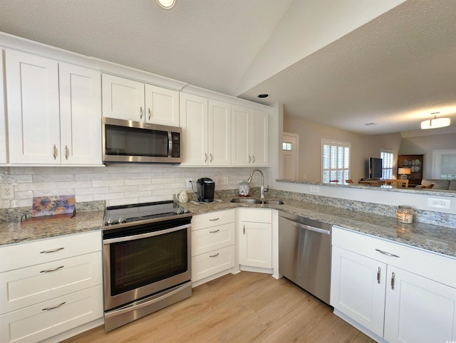 50 Pawleys Place Dr Unit 50, Pawleys Island, SC 29585 - kitchen with appliances with stainless steel finishes, a textured ceiling, decorative backsplash, white cabinets, and vaulted ceiling