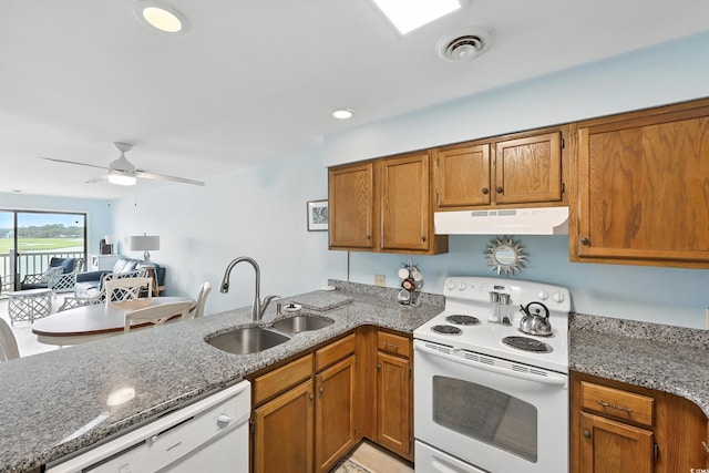 312 42nd Ave N Unit B2, North Myrtle Beach, SC 29582 - kitchen with white appliances, under cabinet range hood, a peninsula, brown cabinets, and stone counters