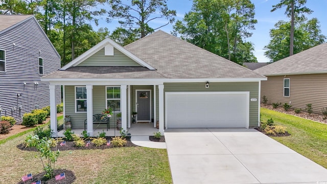 688 Wallace Dr, Little River, SC 29566 - view of front facade featuring covered porch, roof with shingles, an attached garage, concrete driveway, and a front lawn