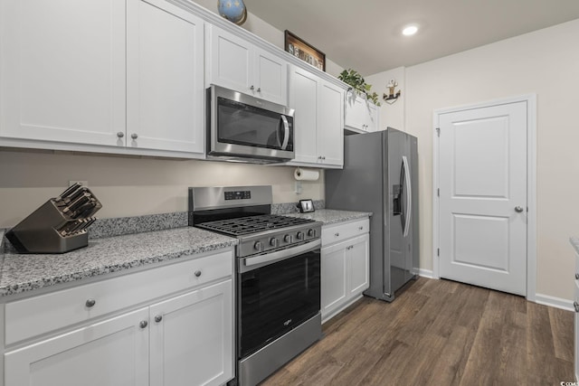 688 Wallace Dr, Little River, SC 29566 - kitchen featuring appliances with stainless steel finishes, dark wood finished floors, white cabinets, light stone countertops, and recessed lighting