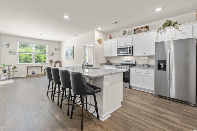 688 Wallace Dr, Little River, SC 29566 - kitchen featuring stainless steel appliances, dark wood-style floors, an island with sink, white cabinetry, and recessed lighting