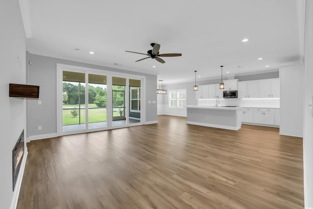 529 Oak Lawn Rd, Georgetown, SC 29440 - unfurnished living room featuring ceiling fan, recessed lighting, light wood-style flooring, and a lit fireplace