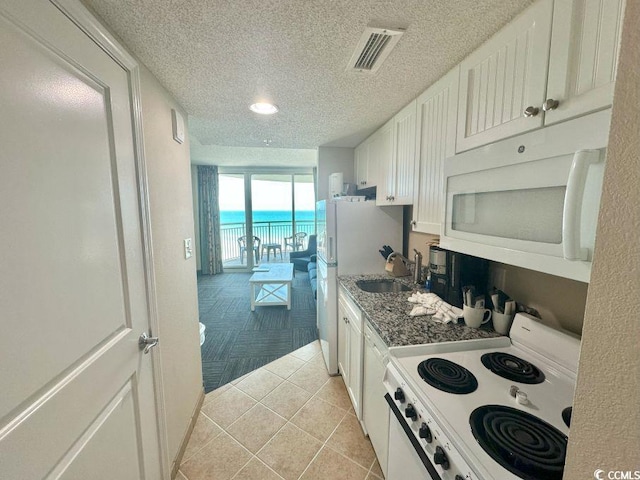 300 N Ocean Blvd Unit 1213, North Myrtle Beach, SC 29582 - kitchen featuring white appliances, a textured ceiling, white cabinetry, light tile patterned floors, and recessed lighting