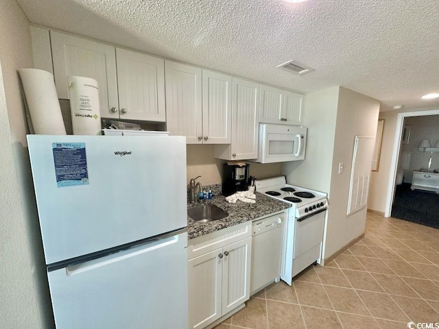 300 N Ocean Blvd Unit 1213, North Myrtle Beach, SC 29582 - kitchen featuring white appliances, light tile patterned floors, white cabinets, a textured ceiling, and stone countertops
