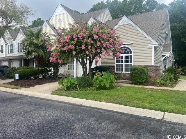 110 Palisade Loop Unit 110, Pawleys Island, SC 29585 - obstructed view of property with brick siding, roof with shingles, and a front lawn