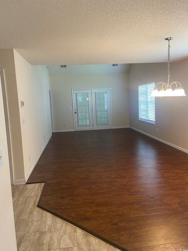 110 Palisade Loop Unit 110, Pawleys Island, SC 29585 - spare room with wood finished floors, a textured ceiling, and a chandelier