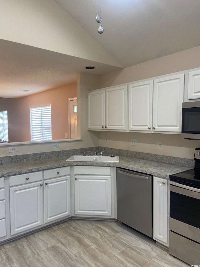 110 Palisade Loop Unit 110, Pawleys Island, SC 29585 - kitchen with stainless steel appliances, white cabinetry, and lofted ceiling