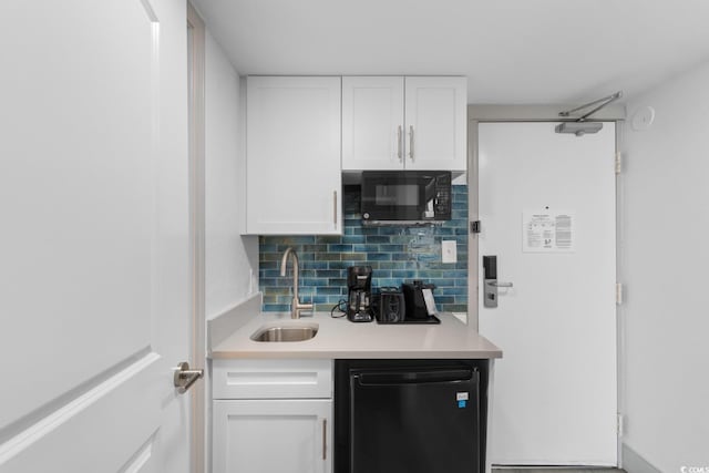 2311 S Ocean Blvd Unit 143, Myrtle Beach, SC 29577 - kitchen with black appliances, white cabinetry, light countertops, and backsplash