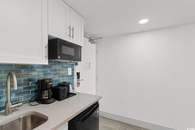 2311 S Ocean Blvd Unit 143, Myrtle Beach, SC 29577 - kitchen featuring black appliances, white cabinetry, tasteful backsplash, light countertops, and recessed lighting