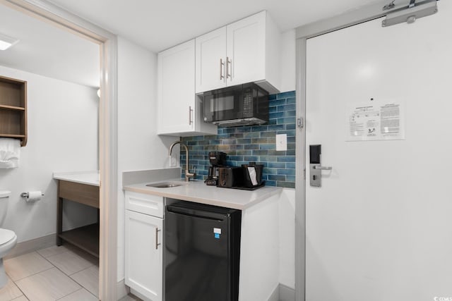 2311 S Ocean Blvd Unit 143, Myrtle Beach, SC 29577 - kitchen with black microwave, dishwasher, decorative backsplash, white cabinets, and light countertops