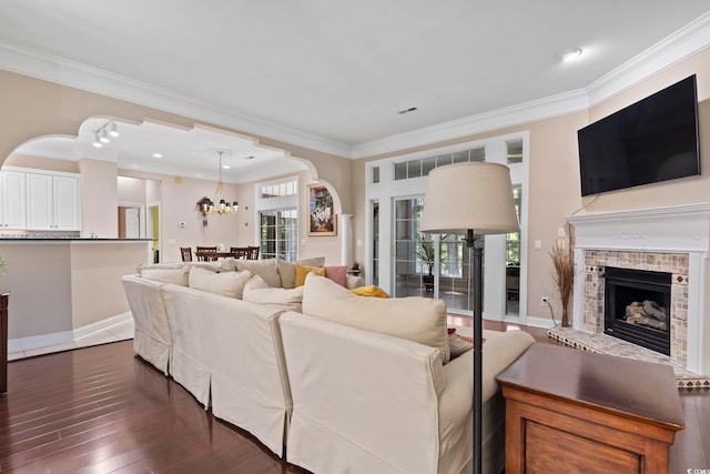 4495 Trotters Ct, Murrells Inlet, SC 29576 - living area featuring crown molding, plenty of natural light, a chandelier, a fireplace with raised hearth, and dark wood-style flooring