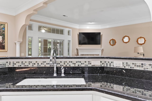 4495 Trotters Ct, Murrells Inlet, SC 29576 - detailed view of ornamental molding, arched walkways, backsplash, dark countertops, and ceiling fan
