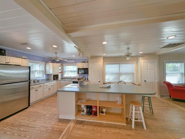 206 Atlantic Ave, Pawleys Island, SC 29585 - kitchen featuring freestanding refrigerator, open shelves, a ceiling fan, light wood finished floors, and a center island
