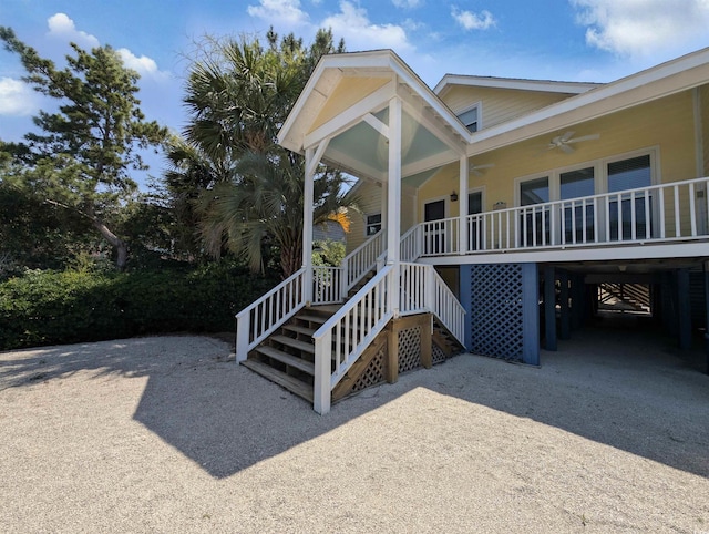 206 Atlantic Ave, Pawleys Island, SC 29585 - view of front of house with ceiling fan, a carport, a porch, driveway, and stairway