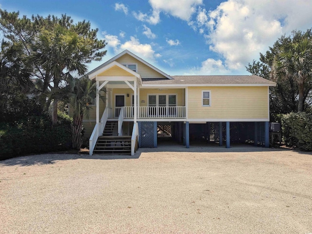 206 Atlantic Ave, Pawleys Island, SC 29585 - coastal inspired home featuring stairway, a porch, a carport, driveway, and a shingled roof