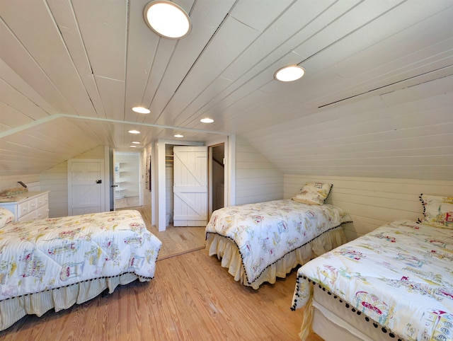 206 Atlantic Ave, Pawleys Island, SC 29585 - bedroom with lofted ceiling, light wood-type flooring, and wood walls