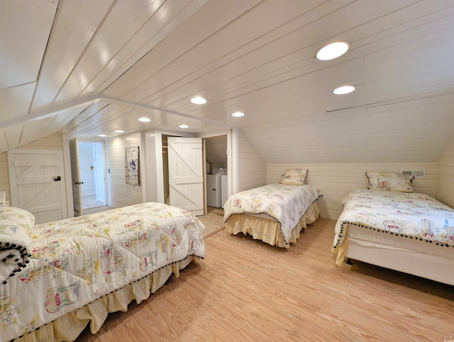206 Atlantic Ave, Pawleys Island, SC 29585 - bedroom with washing machine and clothes dryer, light wood-style flooring, vaulted ceiling, wood walls, and recessed lighting