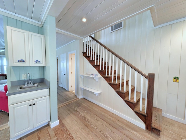 206 Atlantic Ave, Pawleys Island, SC 29585 - staircase featuring wood finished floors, wet bar, and ornamental molding