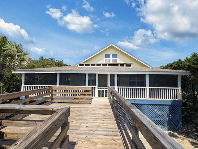 206 Atlantic Ave, Pawleys Island, SC 29585 - rear view of property featuring a sunroom, roof with shingles, and a deck