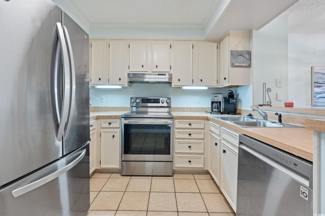 212 N 2nd Ave N Unit 162, North Myrtle Beach, SC 29582 - kitchen with appliances with stainless steel finishes, under cabinet range hood, ornamental molding, light countertops, and light tile patterned flooring
