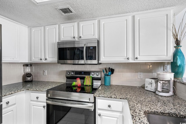 205 74th Ave N Unit 1809, Myrtle Beach, SC 29572 - kitchen with stainless steel appliances, white cabinetry, backsplash, and a textured ceiling